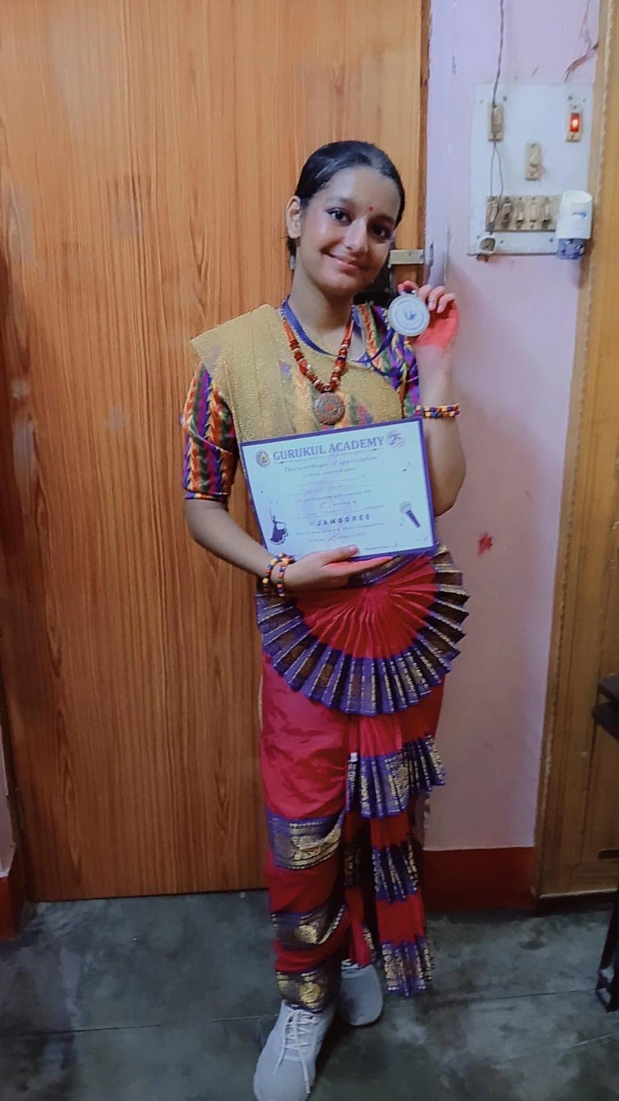 Dance student in full costume holding her certificate and medal