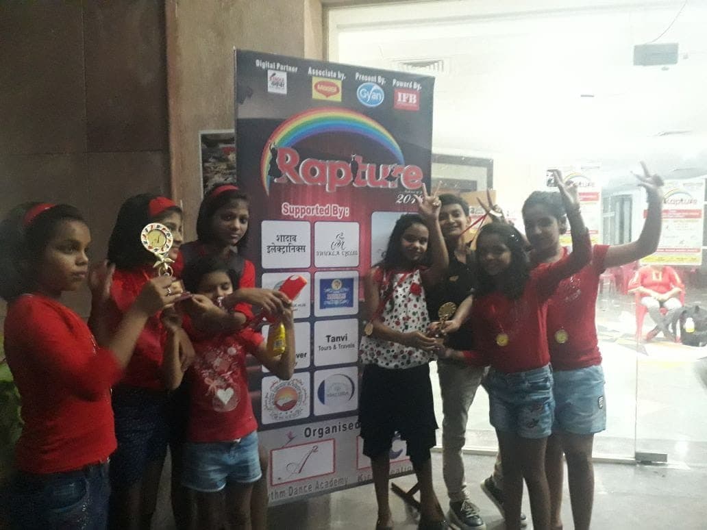 Group of dance students celebrating with trophies and medals