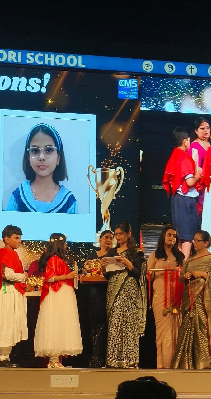 Student being honoured on stage with her photograph on the big screen