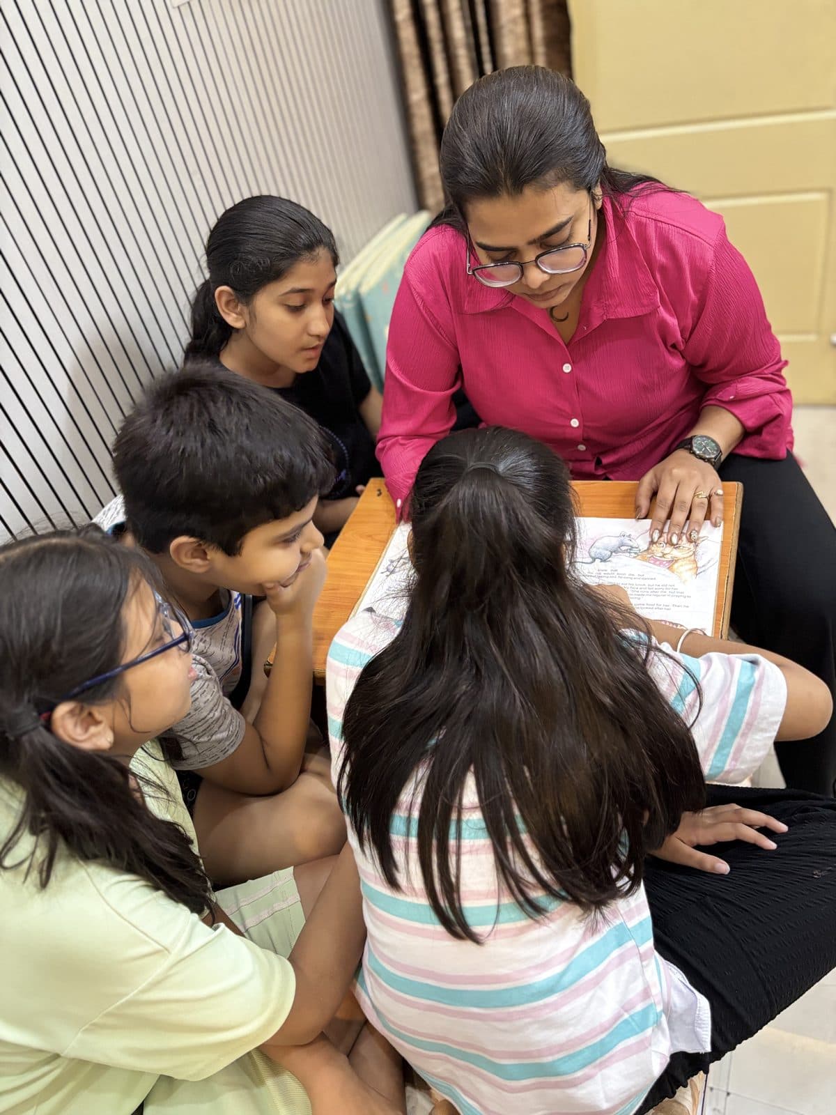 Creative session with students gathered around an illustrated book