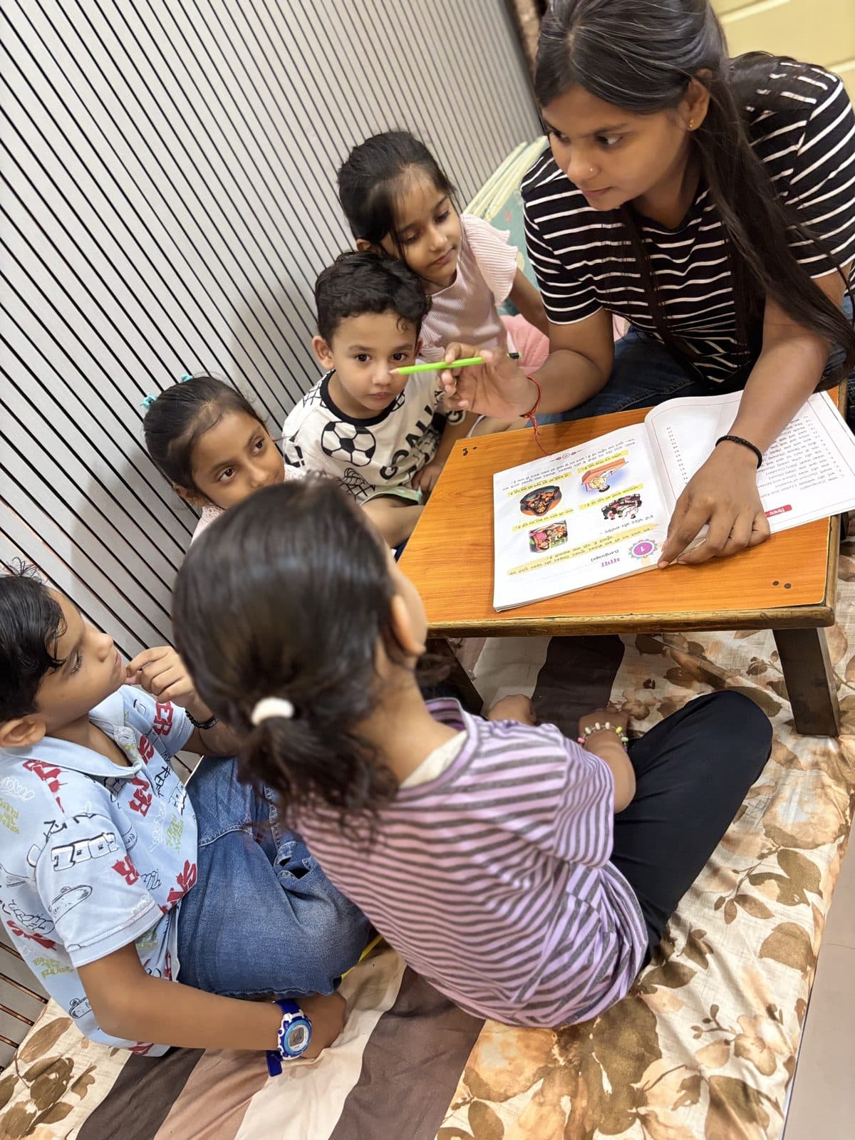 Nursery students reading along as the teacher points to the page