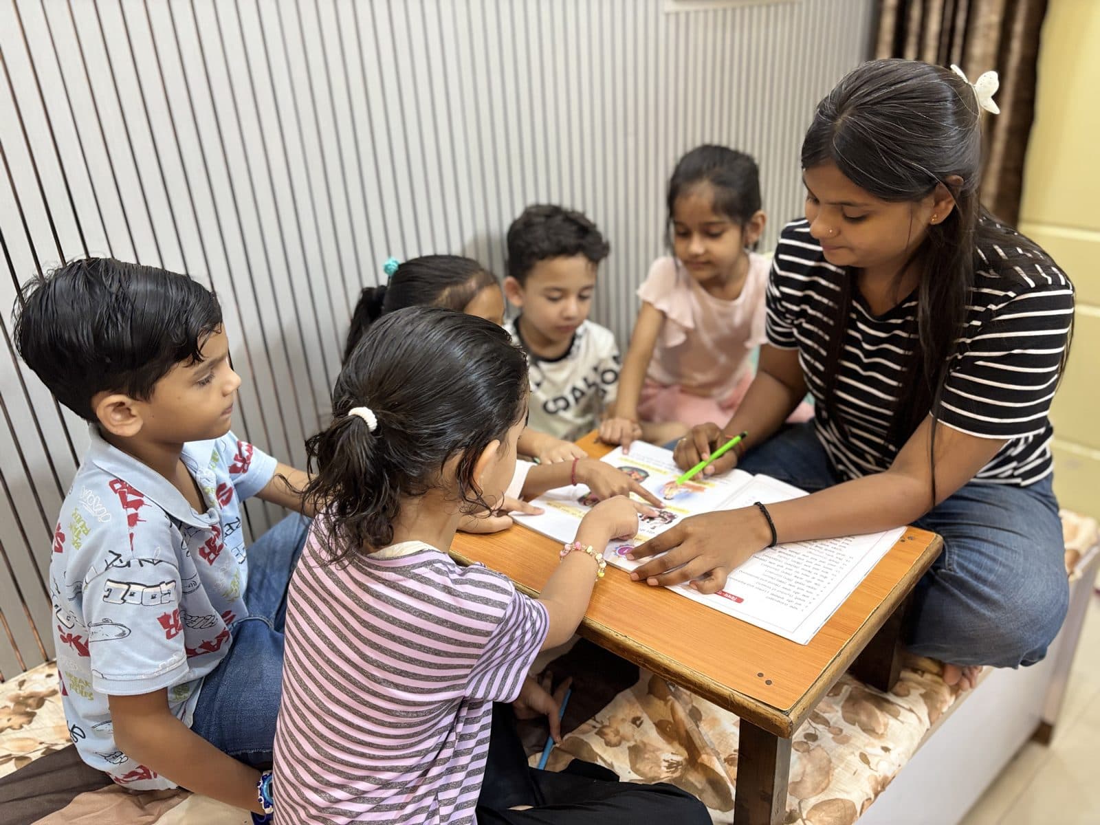 Teacher explaining a chapter to a group of young learners