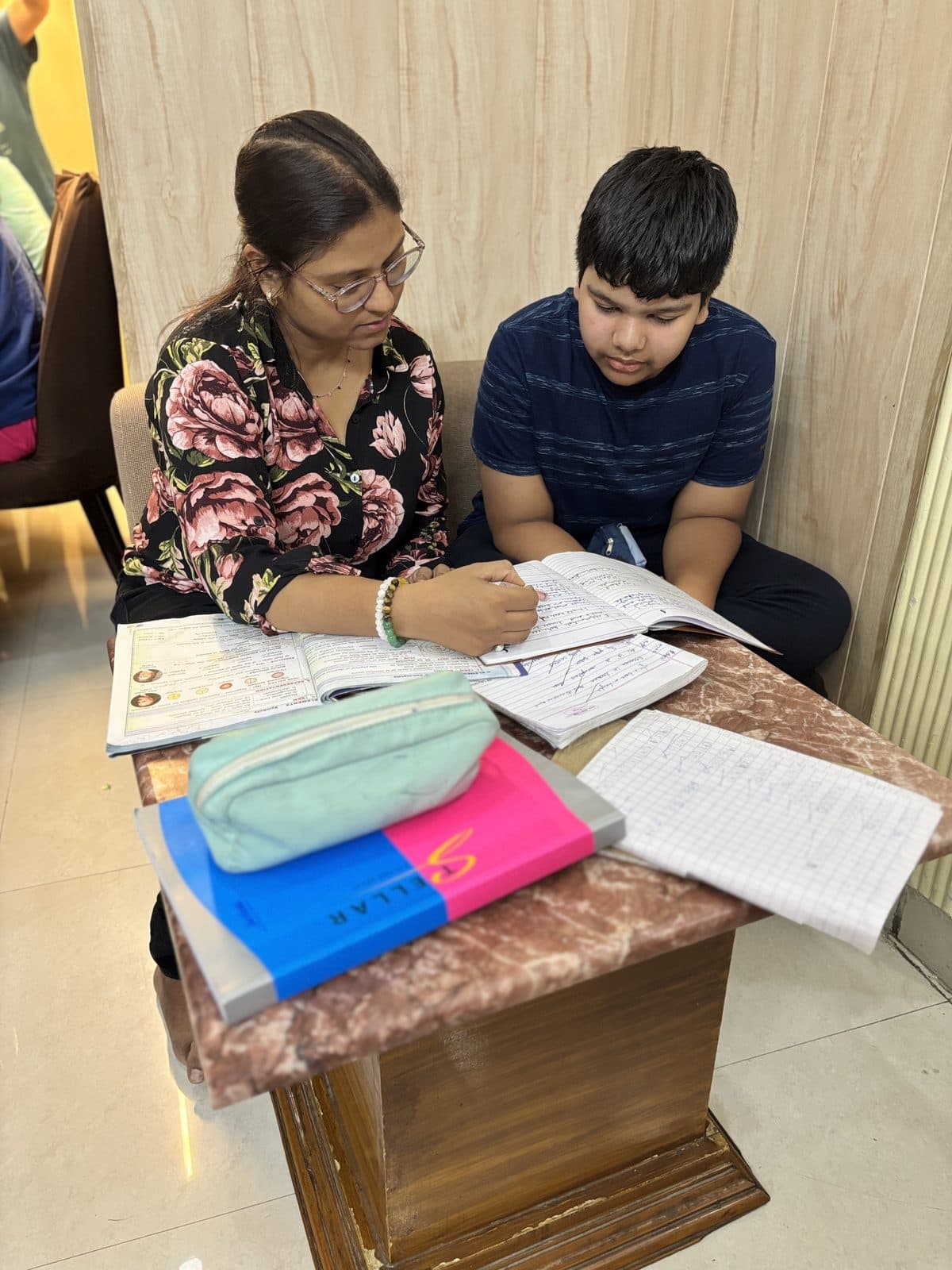 Teacher and student reviewing worksheets side by side