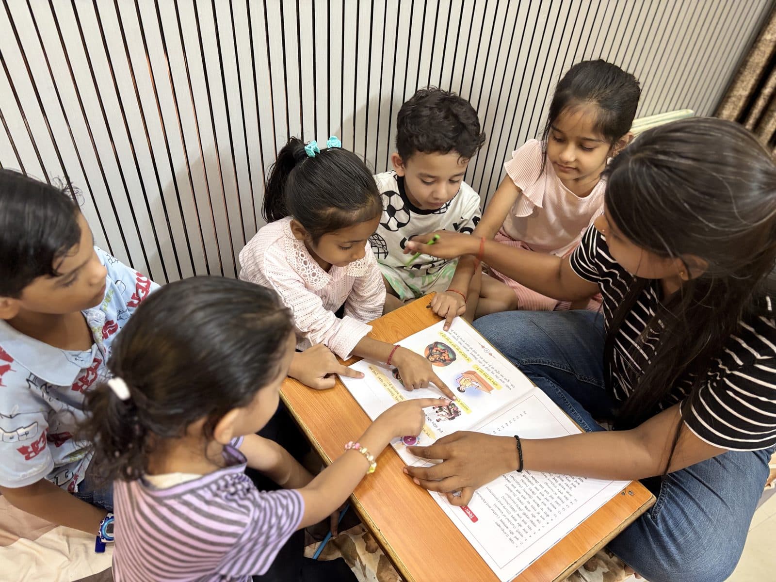 Young students working through an activity with their teacher