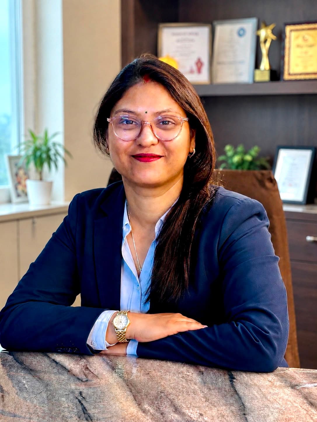Priya Mittal at her desk at Fusion Academy, awards and certificates displayed behind her
